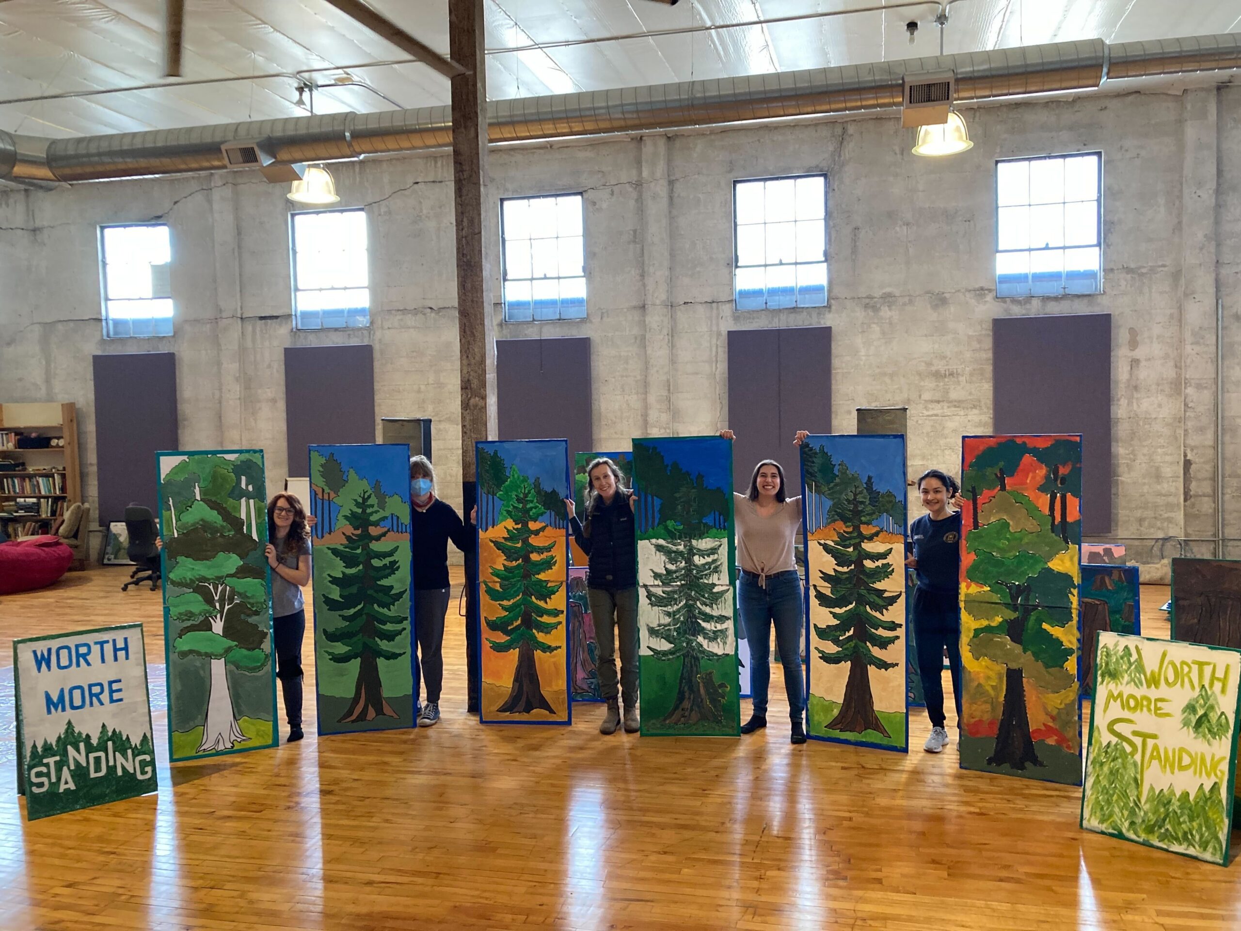 Advocates stand next to their hand-painted signs they made for an Earth Day rally