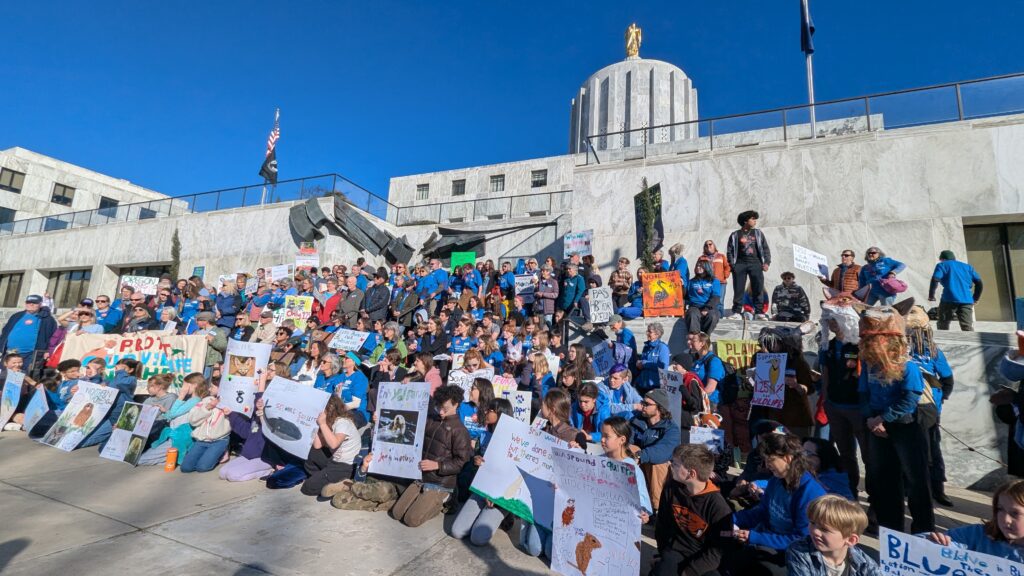 Advocates gather on the Capitol steps in Salem holding signs supporting wildlife and HB 4134