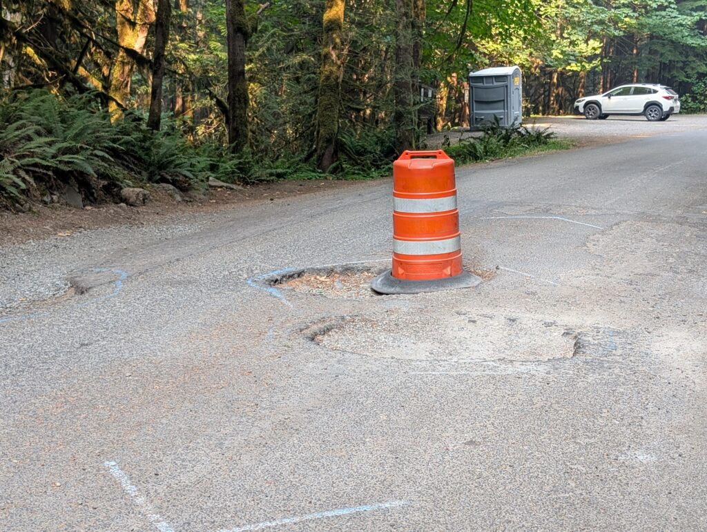 Giant potholes in the middle of the road to the popular Salmon River Trail on the Mount Hood National Forest